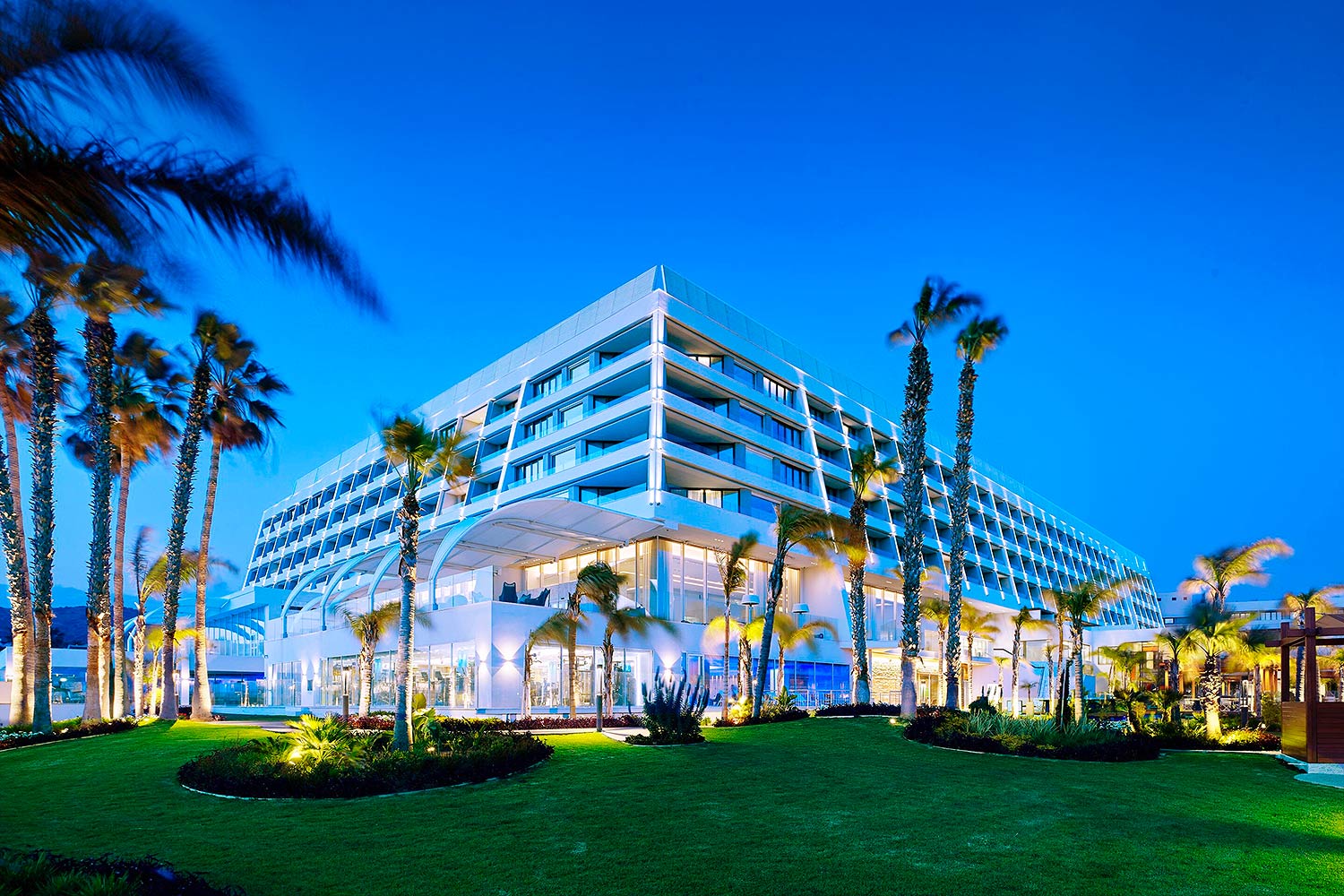Parklane 水疗度假村的外景及转角景观，四周绿草如茵，棕榈树环绕